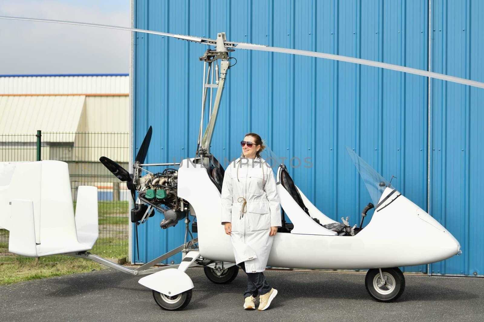 A woman near double white gyrocopter