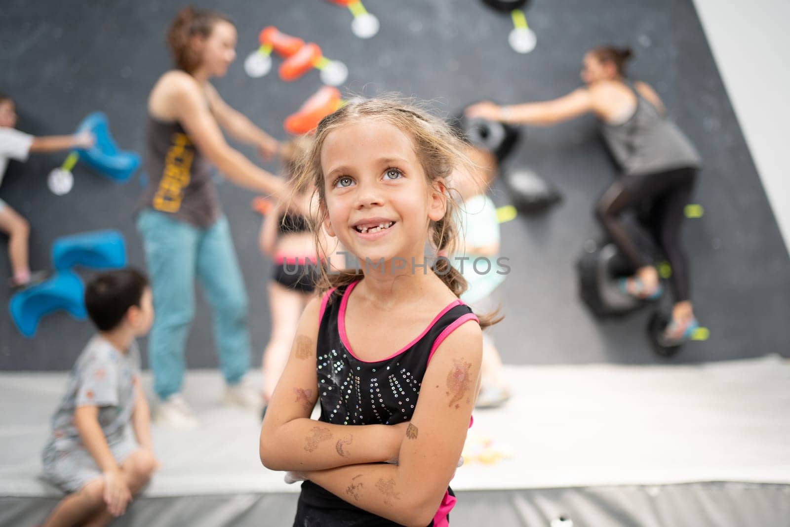 Cute little girl climber standing arms crossed in sports center by andreonegin