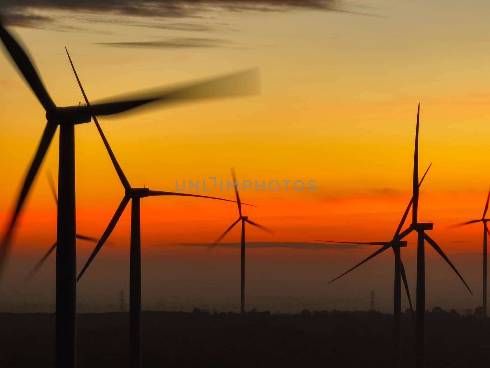 Wind farm landscape against sunset sky. Wind energy. Wind power. Sustainable and renewable energy. Wind turbines generate electricity. Green technology. Renewable resources. Sustainable development. by Fahroni