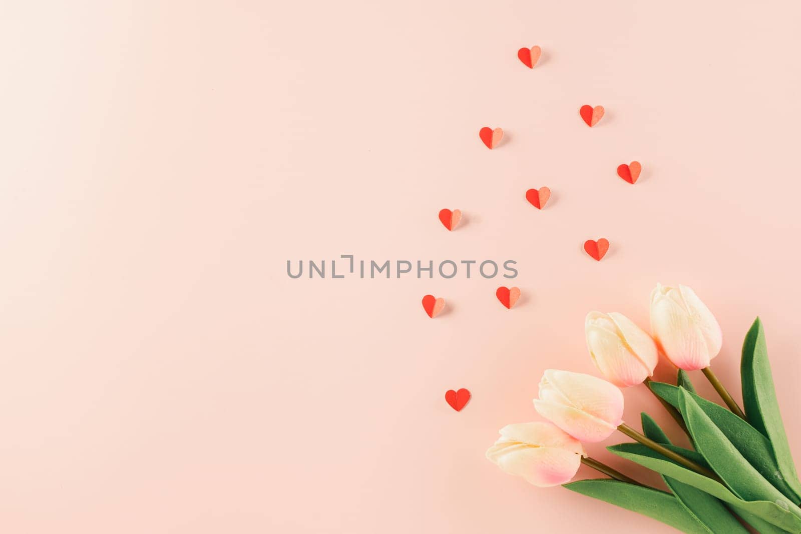 Happy Valentines Day background. Top view flat lay of red paper hearts shape and pink tulips flower on pink background with copy space