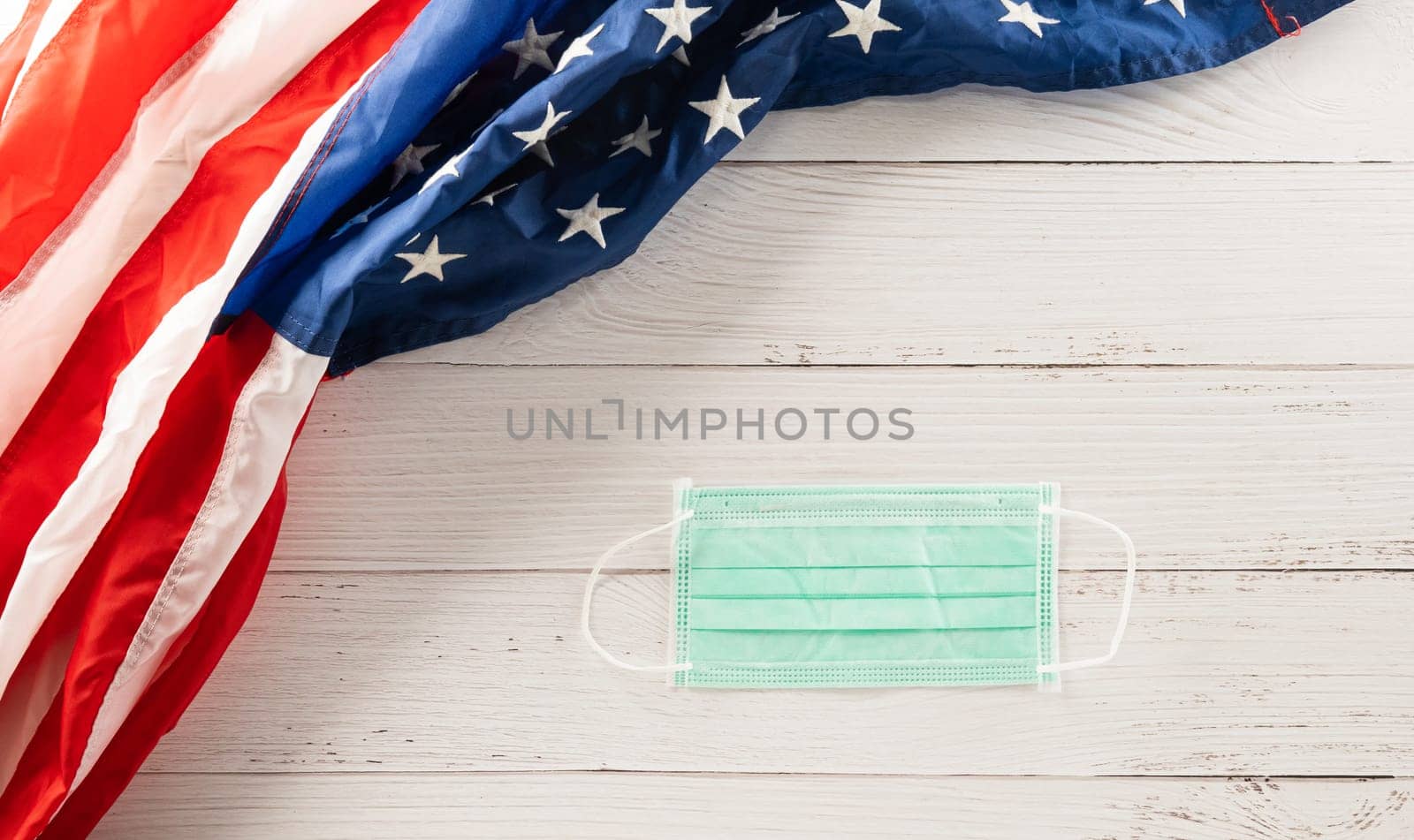 Happy presidents day. flag of United States America with copy space, Top view USA flag and face protection for coronavirus on white wood background board, banner design, Patriot Day, COVID-19