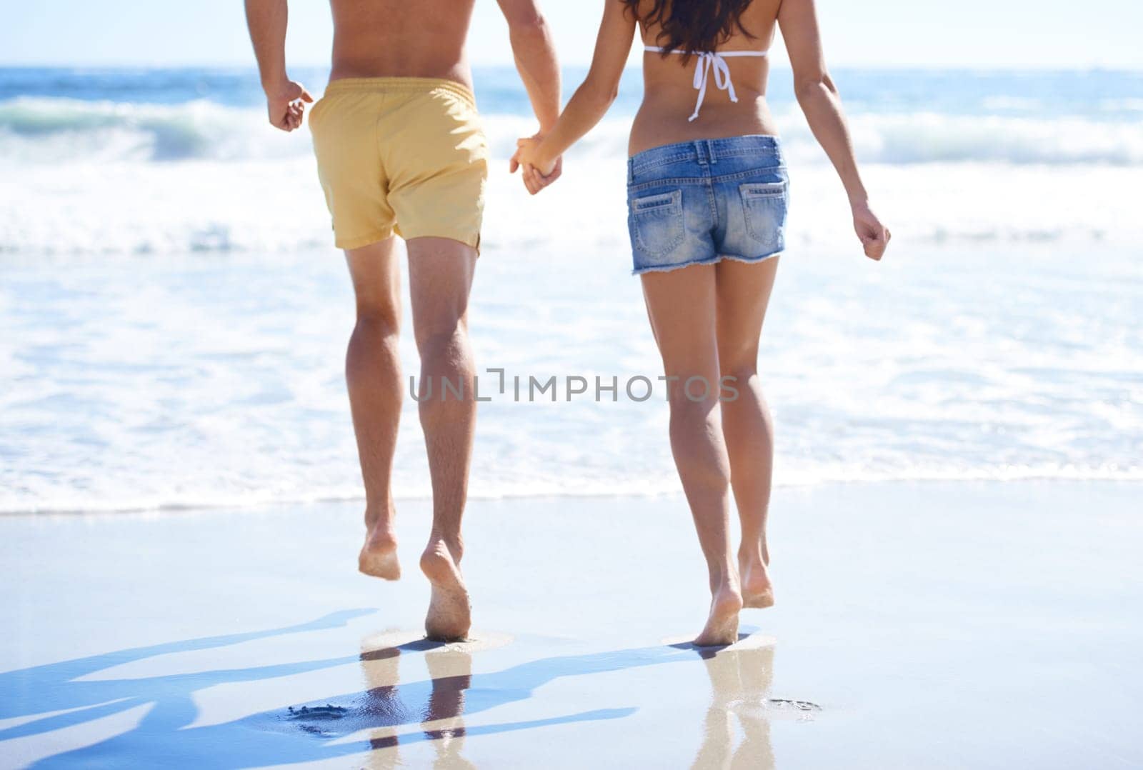 Holding hands, running and couple on beach for holiday adventure together on tropical island with waves. Love, man and woman on ocean vacation with waves, romance and support on travel in Indonesia
