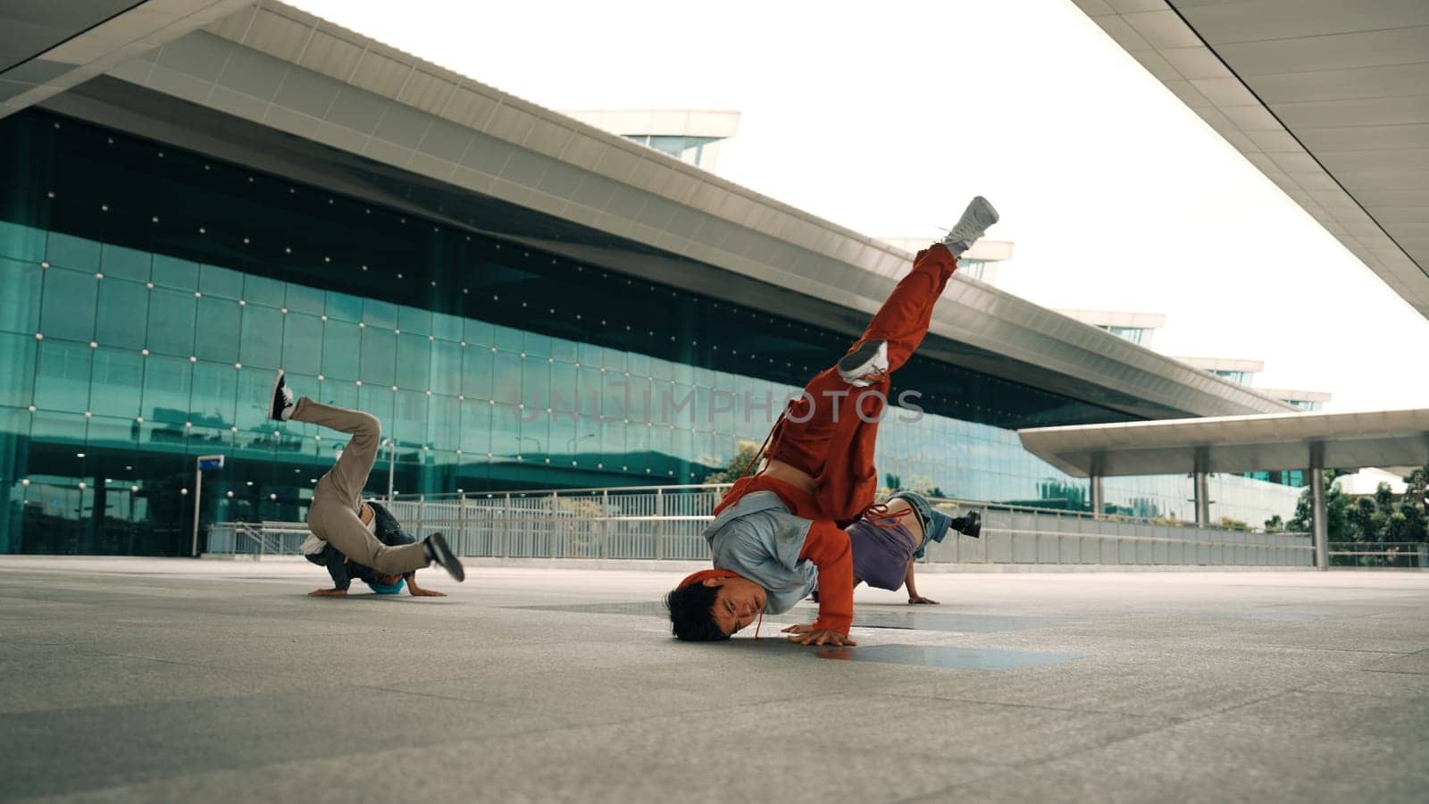 Group of happy hipster or street dancer doing freeze pose in front of mall. Funny energetic break dancer practice b-boy step dancing with friends. Outdoor sport 2024. Street dancer concept. Sprightly.