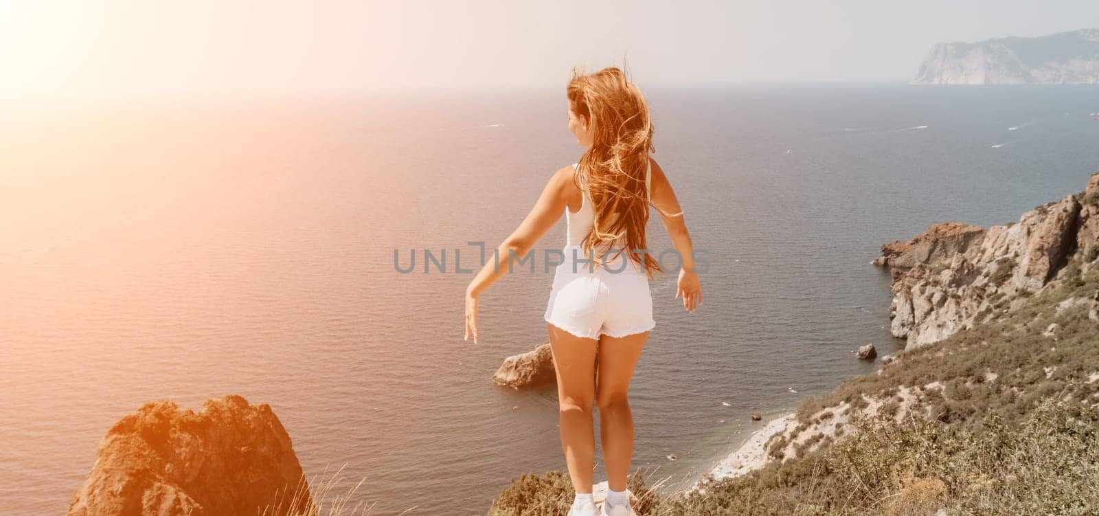 Woman summer travel sea. Happy tourist enjoy taking picture outdoors for memories. Woman traveler posing over sea bay surrounded by volcanic mountains, sharing travel adventure journey by panophotograph