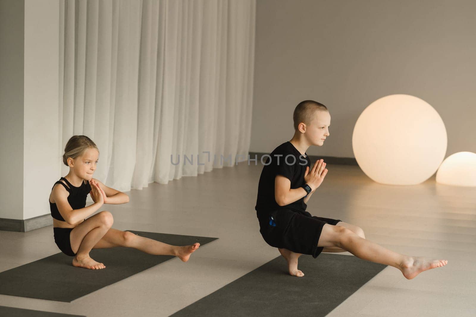 Children do Yoga in the fitness room. Children's gymnastics by Lobachad