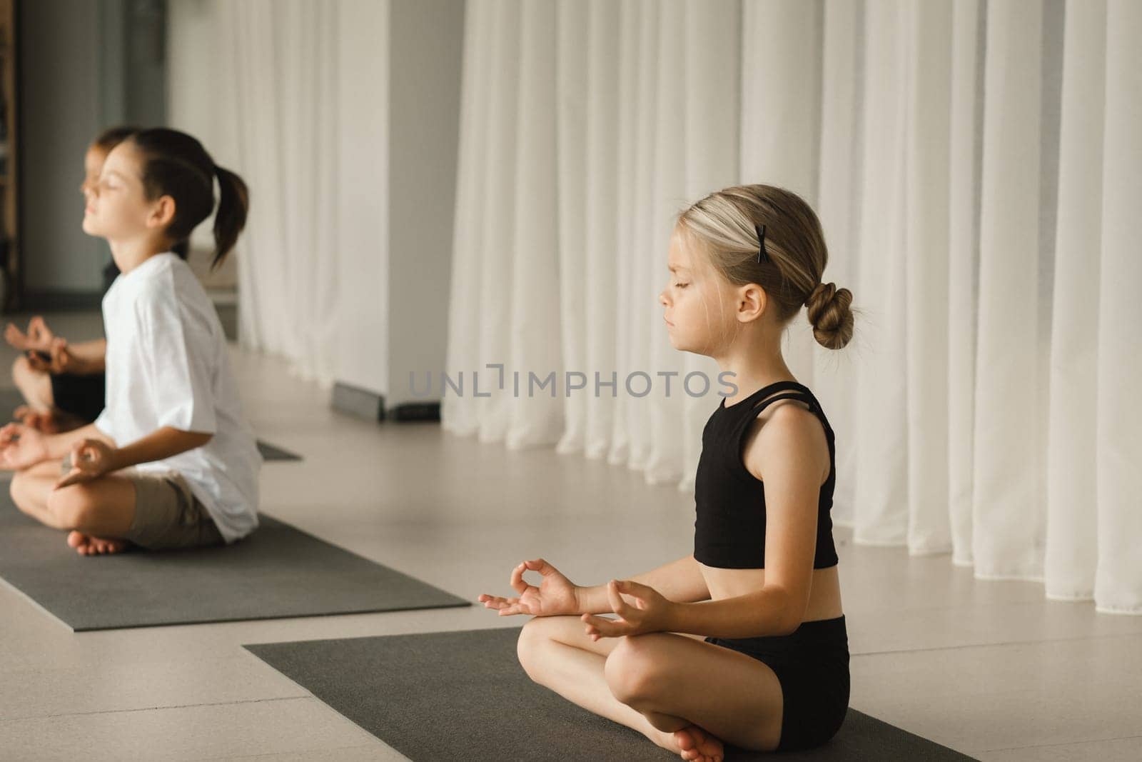 Children do Yoga in the fitness room. Children's gymnastics. by Lobachad