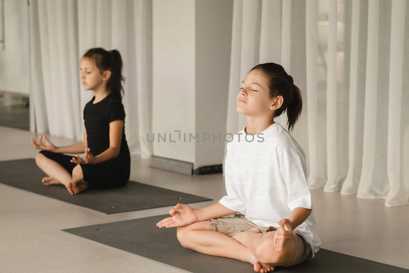 Children do Yoga in the fitness room. Children's gymnastics by Lobachad