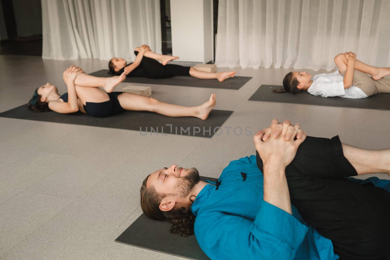 Children do yoga in the gym under the guidance of an instructor. Children's gymnastics by Lobachad