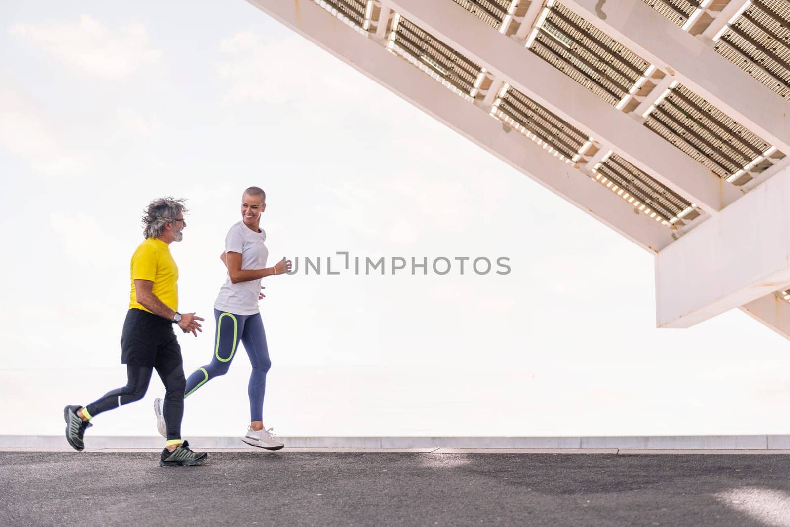 senior sports man running with female trainer by raulmelldo