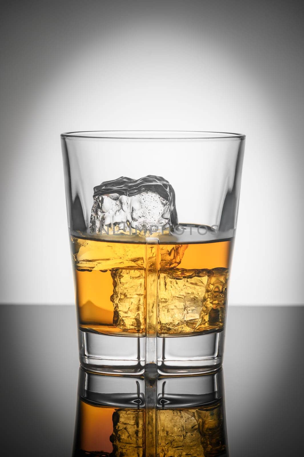 glass of Scotch whiskey with ice on white background