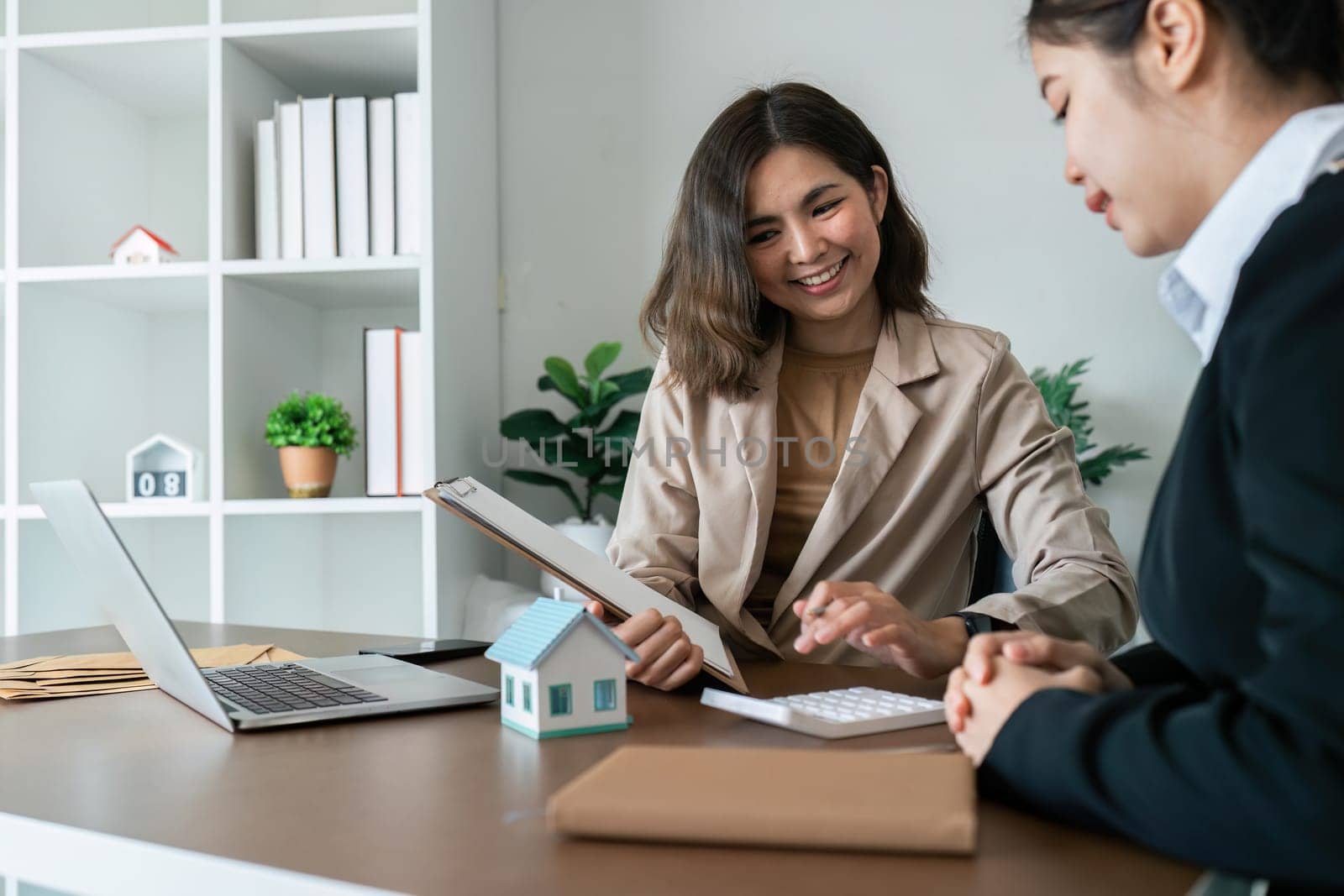 Businesswoman using a calculator to calculate numbers on a company's financial documents, she is analyzing historical financial data to plan how to grow the company. Financial concept by itchaznong