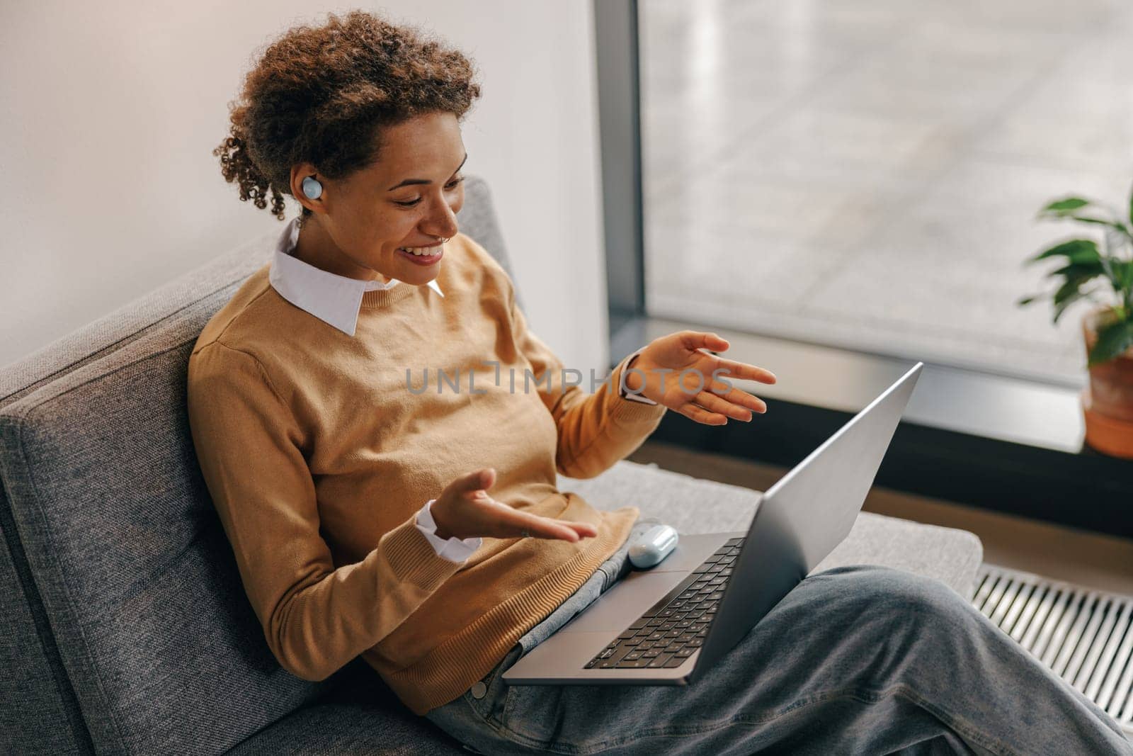 Positive female freelancer have online meeting while sitting in cozy coworking during working day