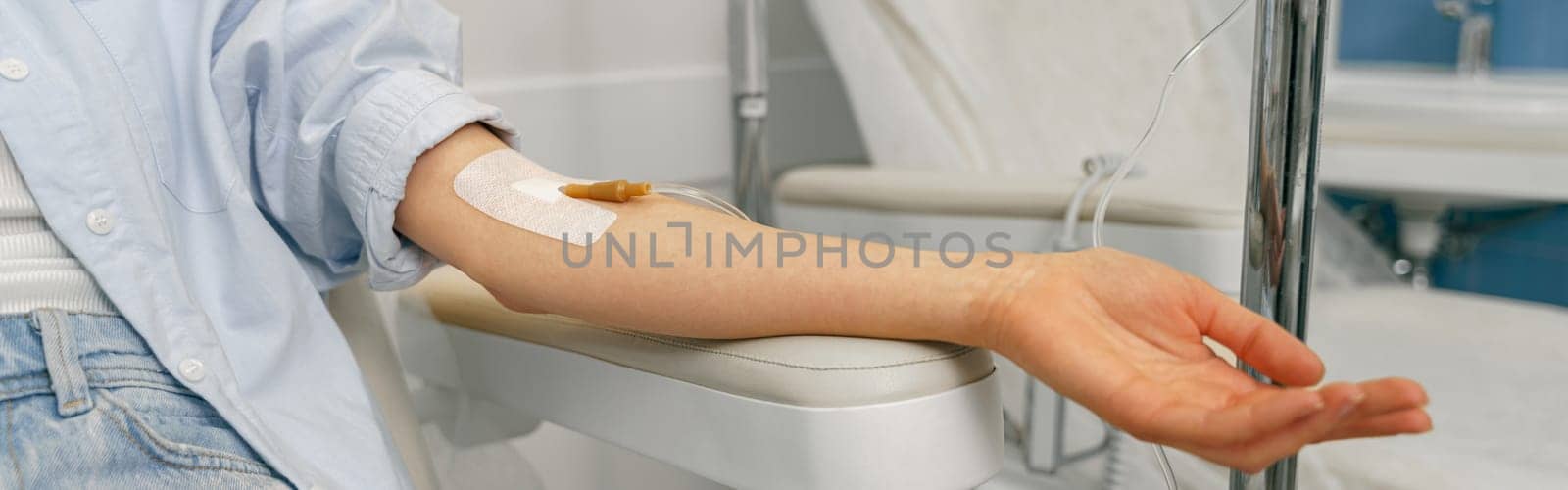 Close up of woman hand with medical drip or IV drip in hospital ward. High quality photo