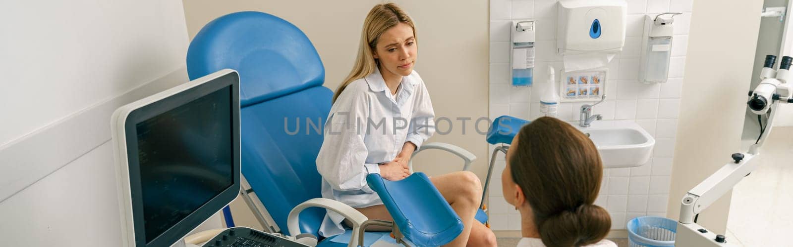 Sad woman on appointment with her gynecologist during regular visit to women's consultation by Yaroslav_astakhov