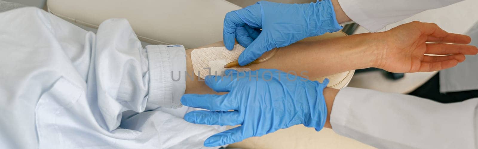 Close-up of doctor putting an IV drip to patient intravenously in hospital ward. High quality photo
