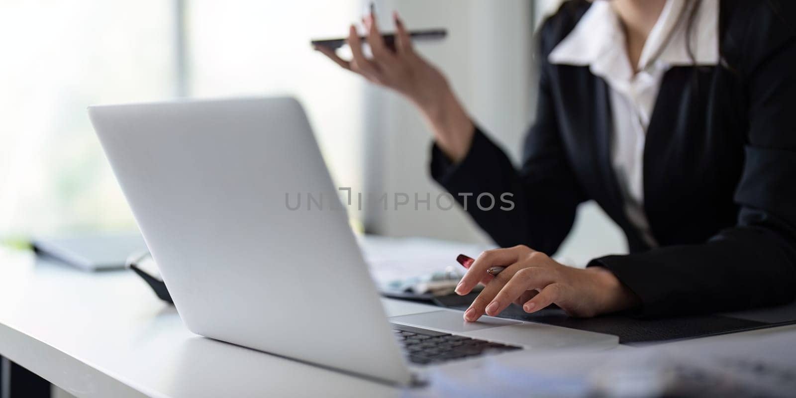 Businesswoman working using laptop computer to record and print information for a marketing plan analyze the balance sheet report financial statement.