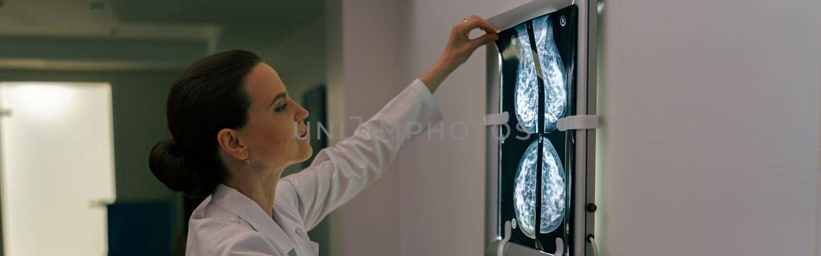 Focused professional doctor radiologist analyzing scan MRI images in medical center by Yaroslav_astakhov