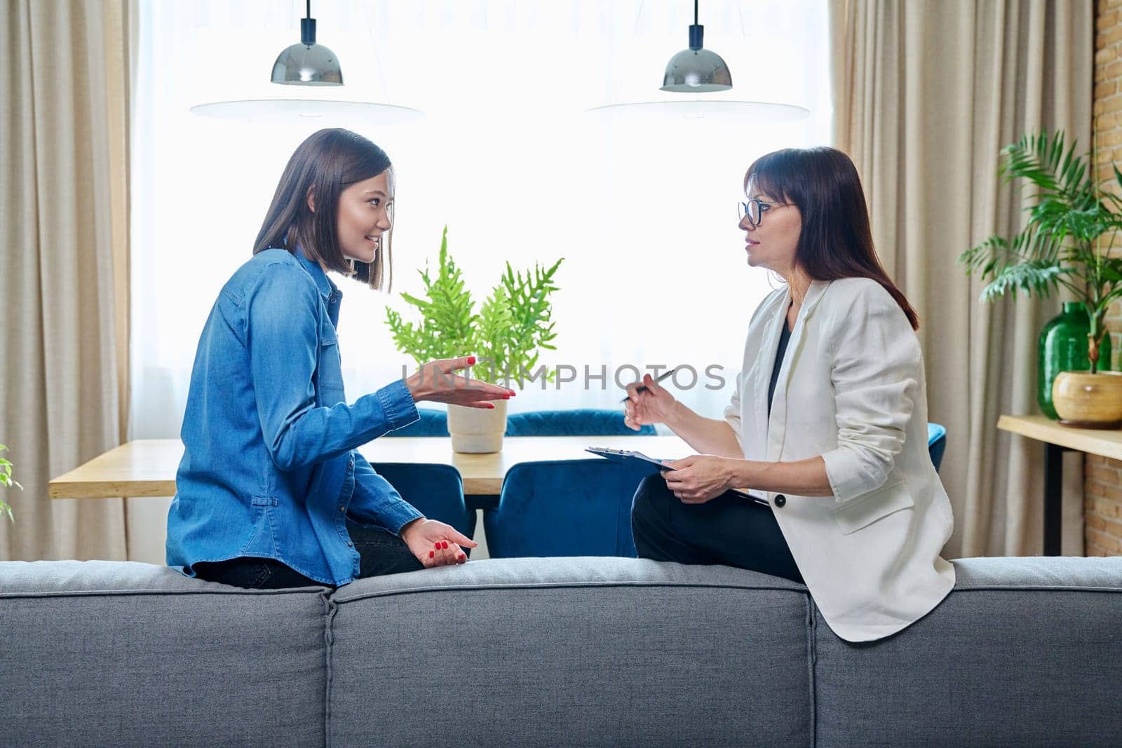 Happy young woman patient talking to female psychologist at therapy by VH-studio