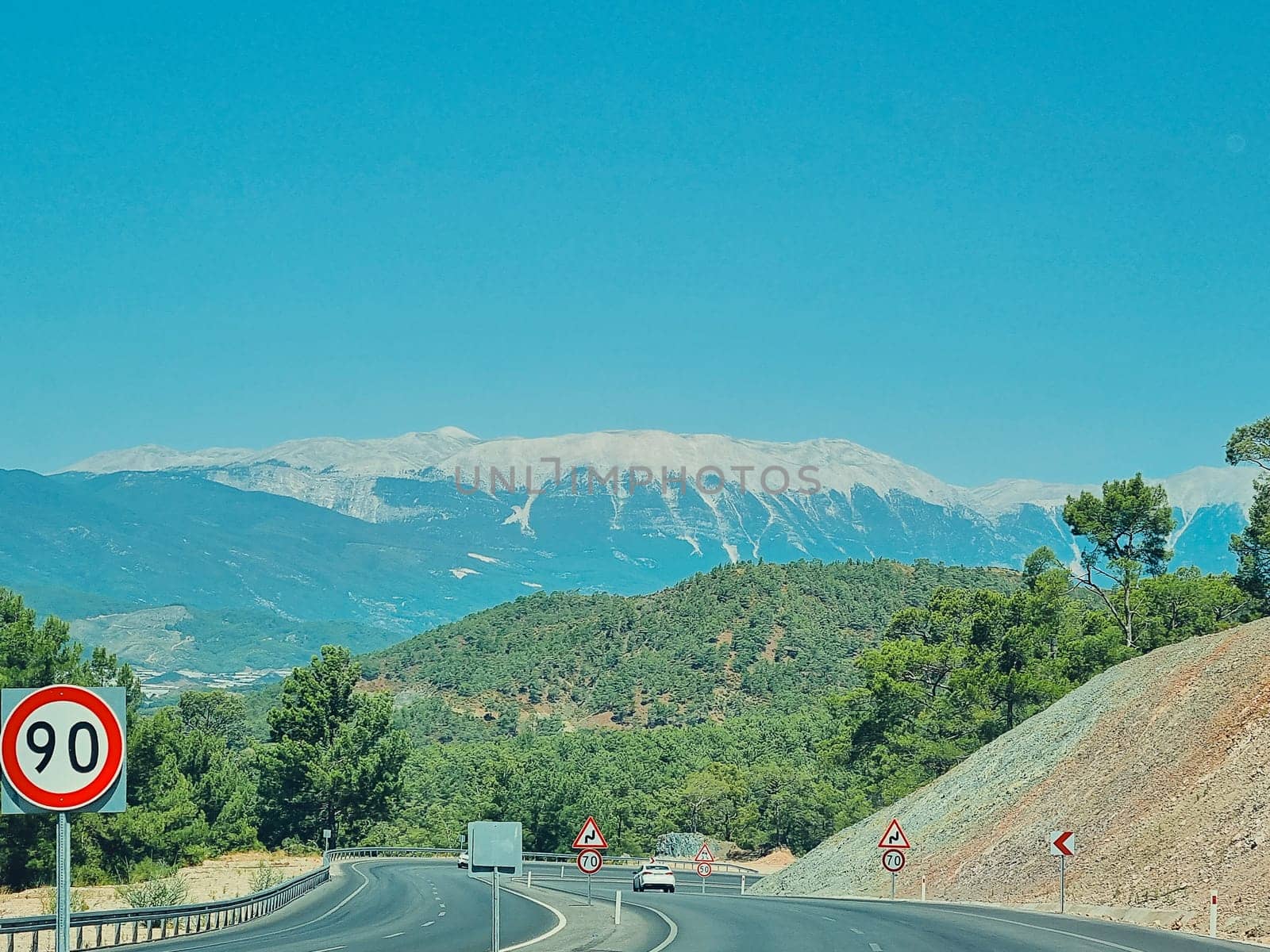 road among forests and mountains with a speed limit on sharp turns. soft focus.