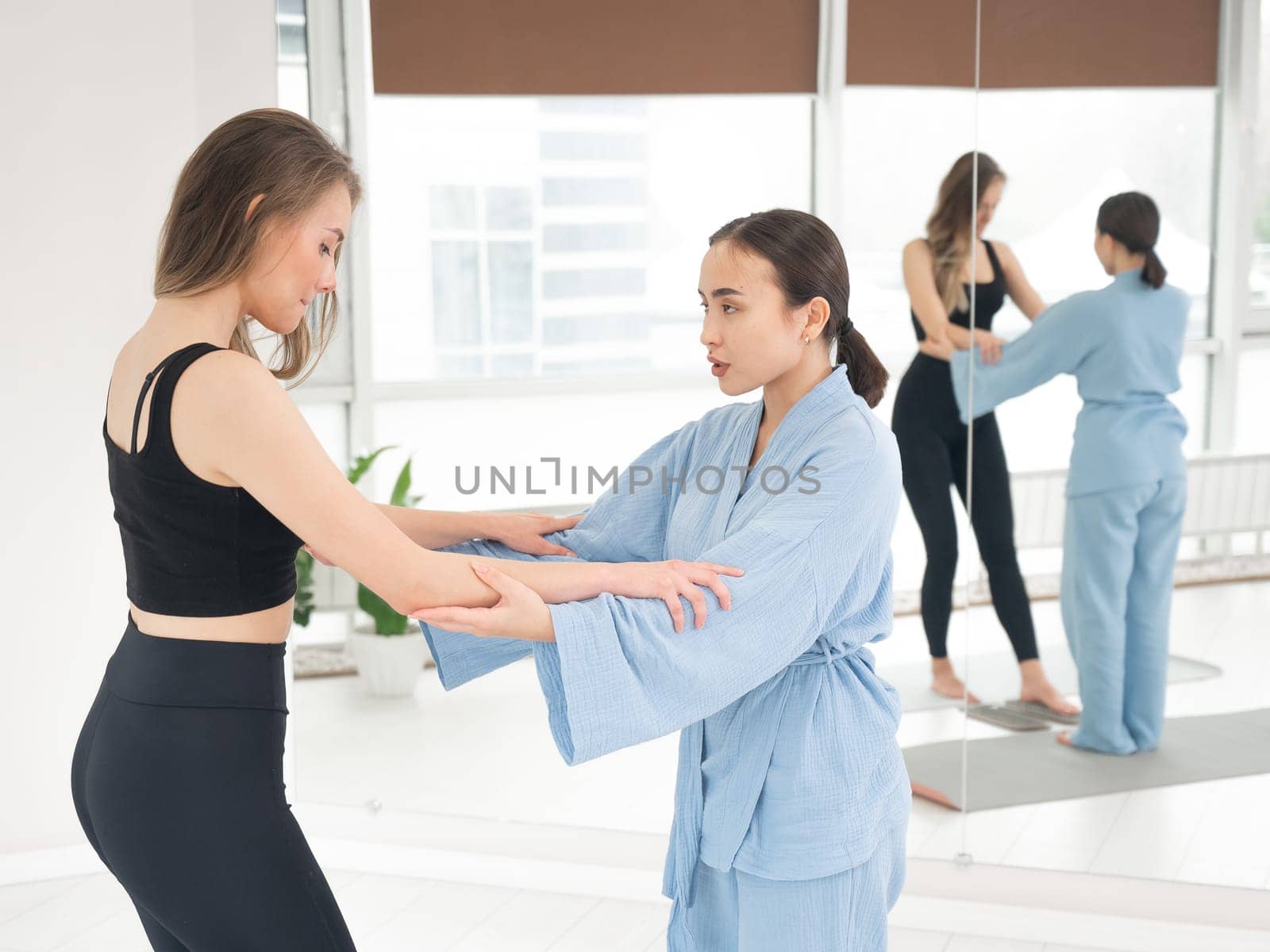 Caucasian woman stands on sadhu boards with therapist support