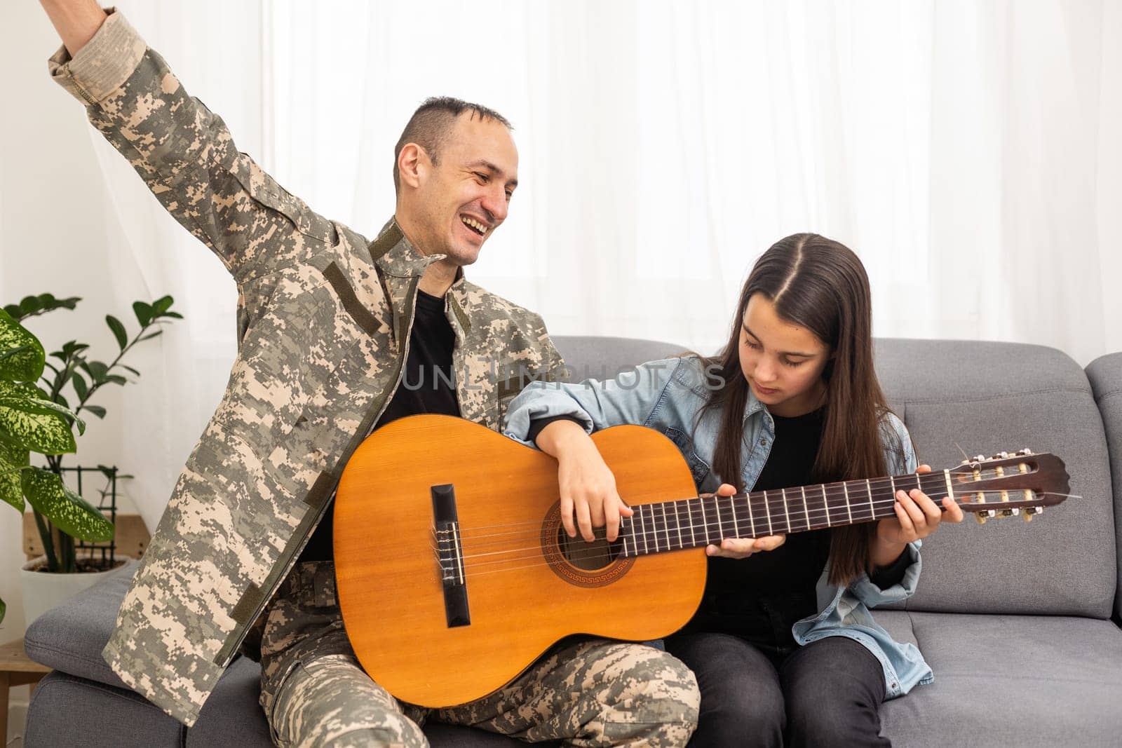 a veteran and his daughter play the guitar. High quality photo