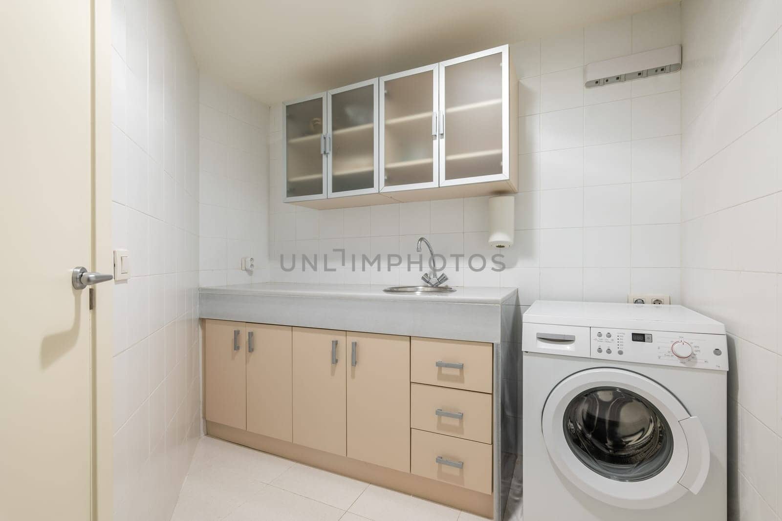 Small laundry room with washing machine sink and storage cabinets. Great room designed for laundry separate from bathroom. Designated area