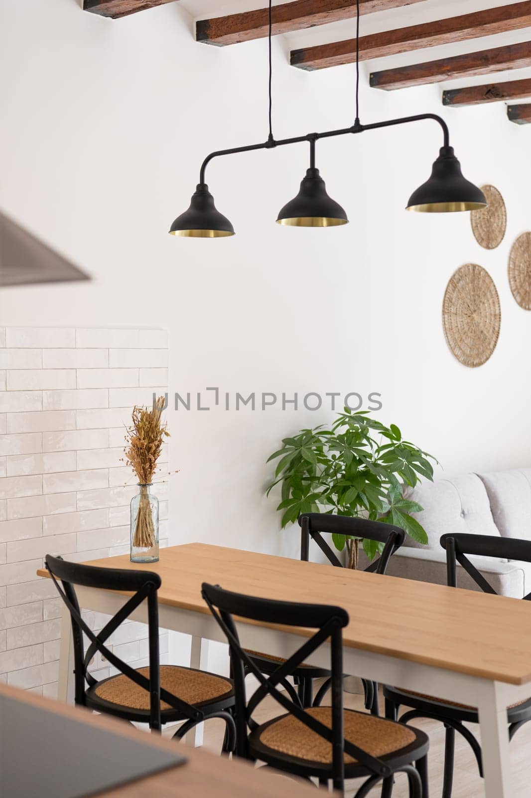 Chandelier over wooden dining table with chairs in studio by apavlin