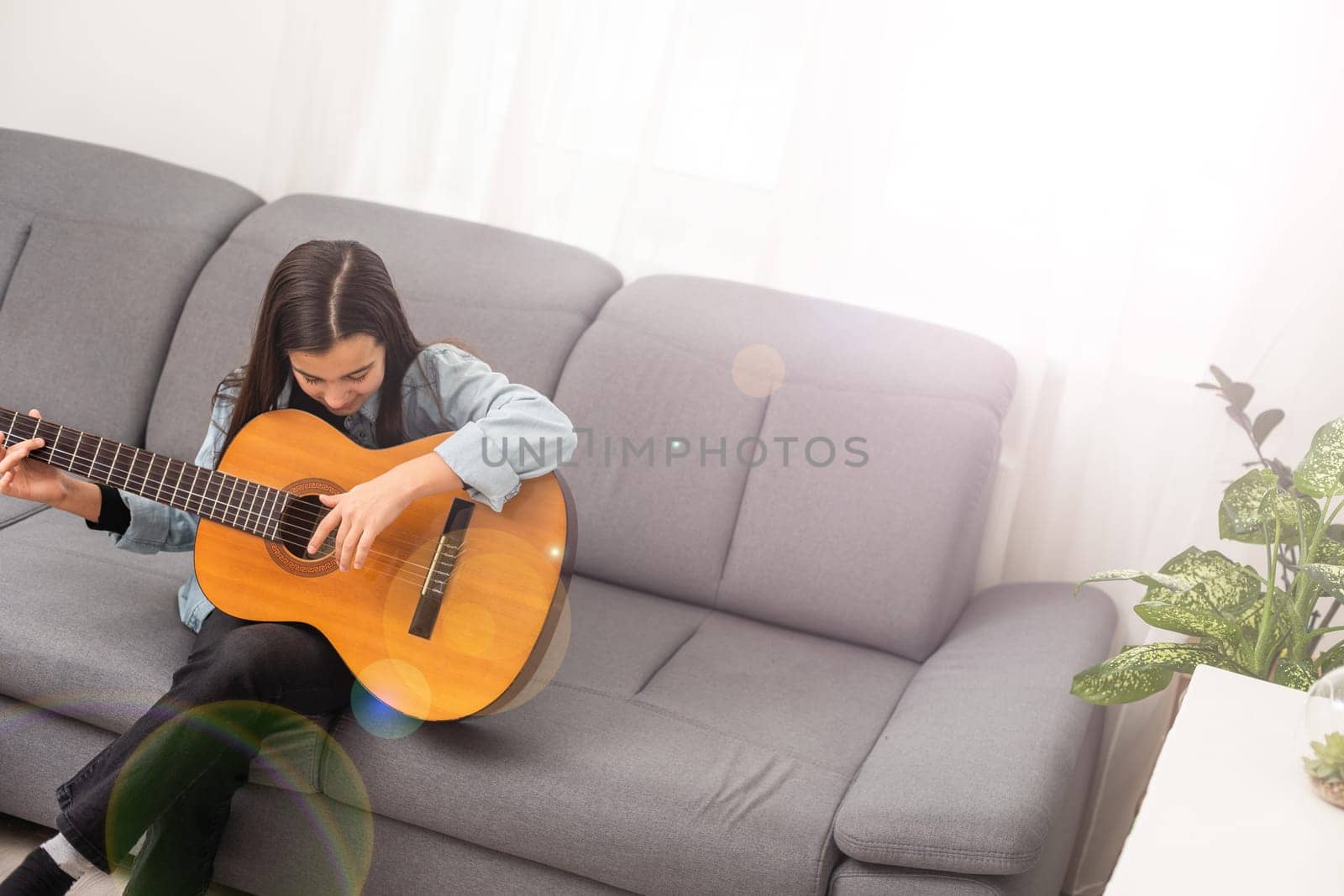 beautiful young girl plays guitar at home by Andelov13
