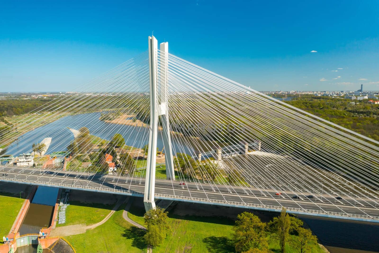 Long pylon bridge spanning Oder river against sunny Wroclaw by vladimka