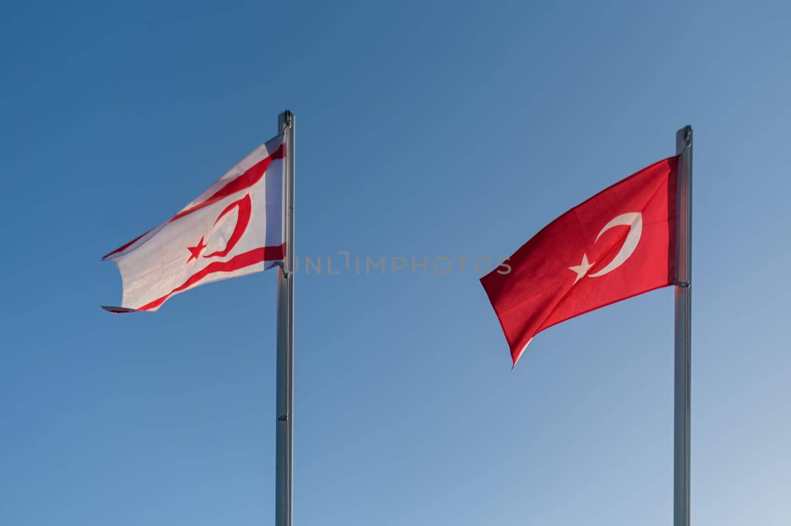 flags of the Turkish Republic of Northern Cyprus and Turkey against the blue sky 2