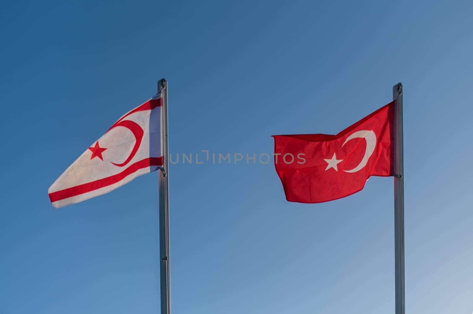 flags of the Turkish Republic of Northern Cyprus and Turkey against the blue sky