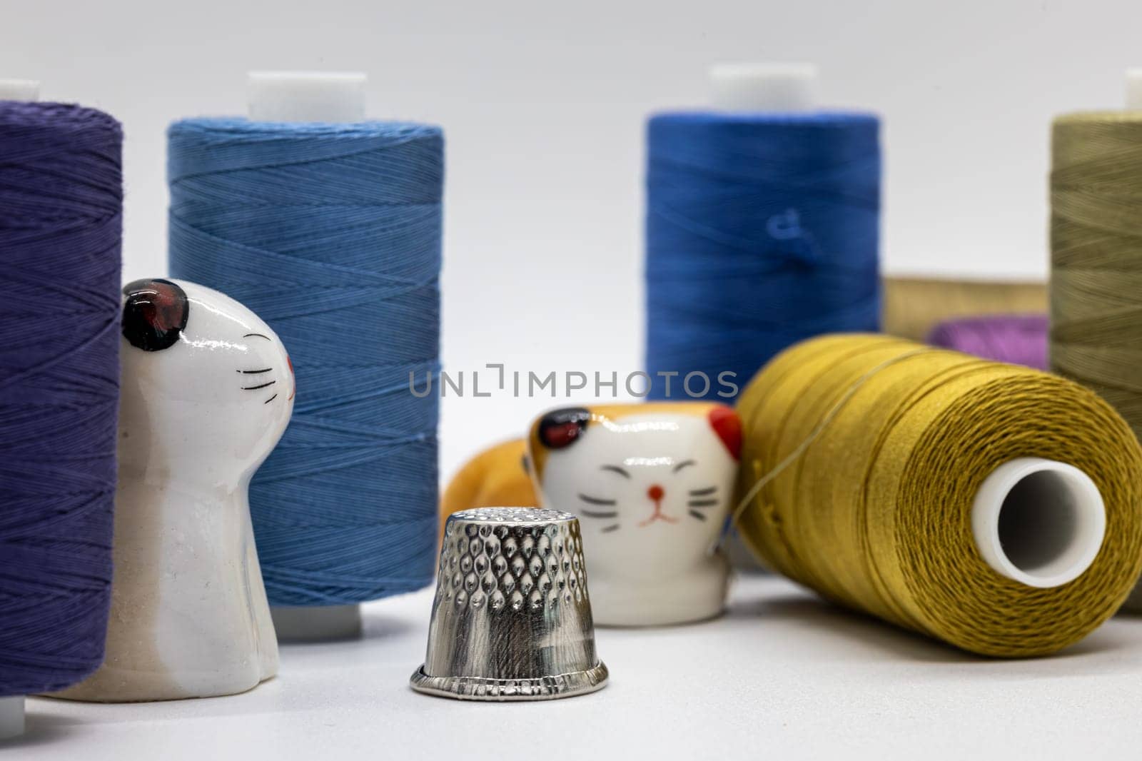 Assorted sewing threads with whimsical cat figurines and metal thimble