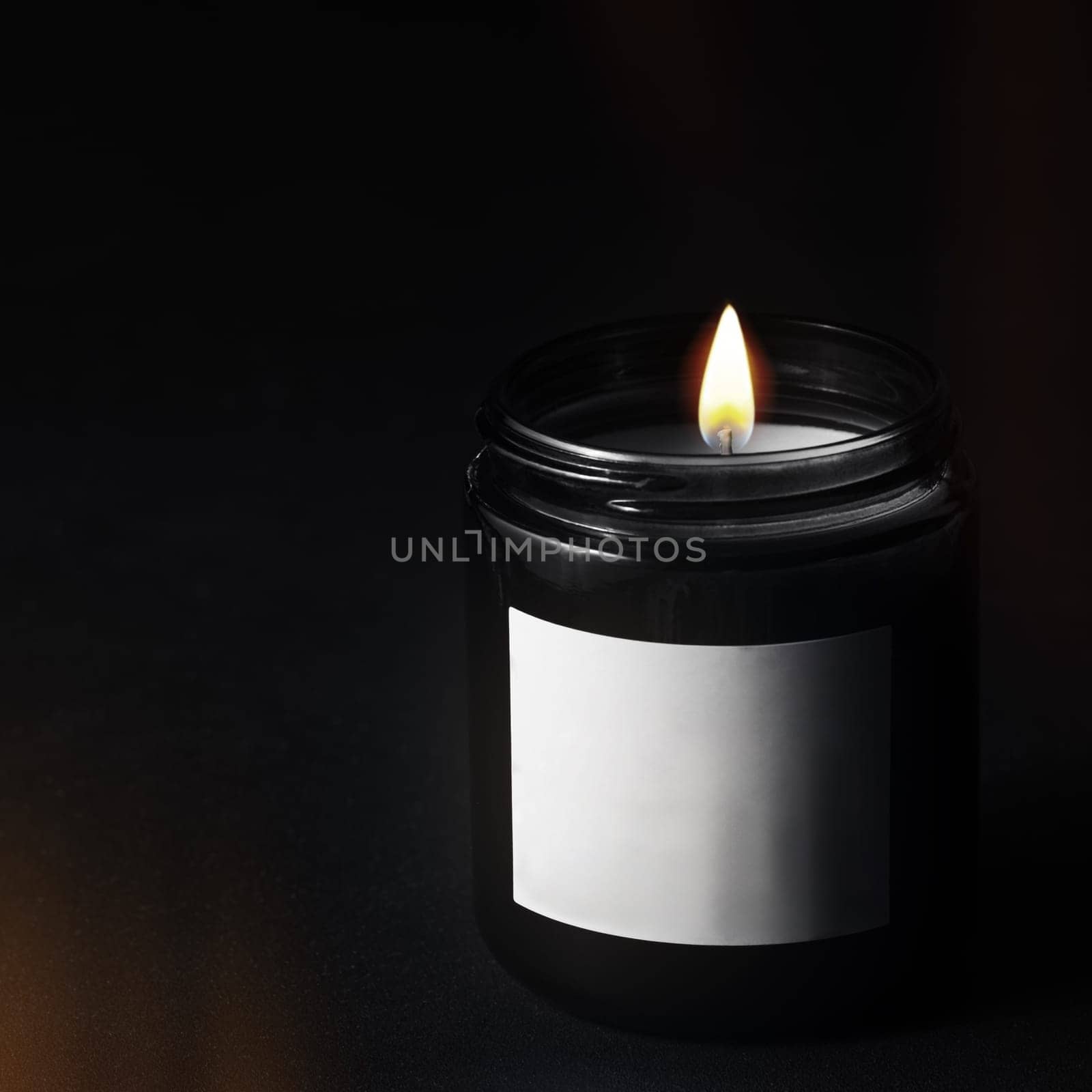 Decorative candle in a black glass jar by clusterx