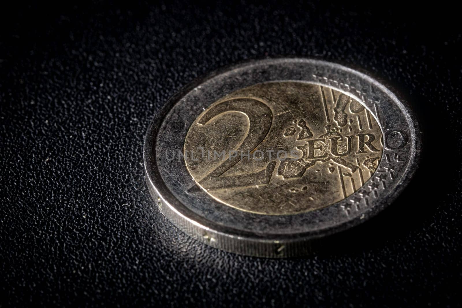 Two euro coin on dark textured background. Close-up macro photography, high angle top view