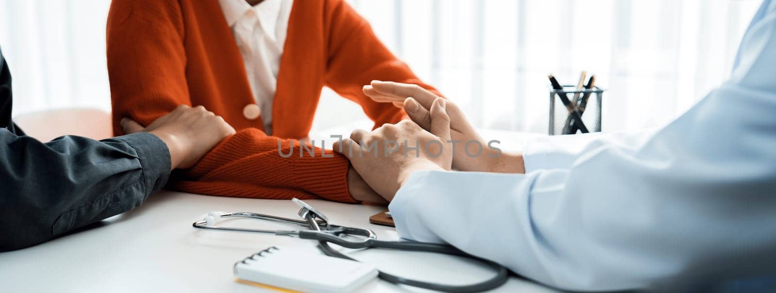 Couple attend fertility or medical consultation with gynecologist at hospital as family planning care for pregnancy while doctor and husband consoling young wife through appointment. Panorama Rigid