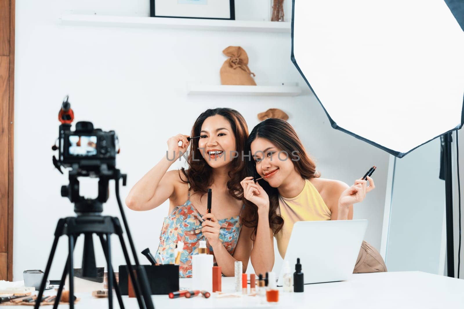 Woman influencer shoot live streaming vlog video review makeup uttermost social media or blog. Happy young girl with cosmetics studio lighting for marketing recording session broadcasting online.