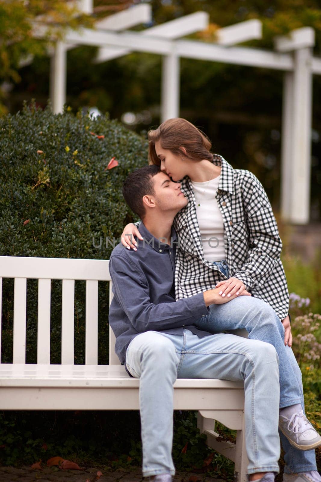 Autumn Romance: Young Couple Embracing and Kissing on Park Bench. Young couple kissing and rejoices at the lake. lovely young couple kissing outdoors in autumn. Embraced in Autumn's Warmth: Couple's Kiss on Park Bench. Loving couple walking in nature. Autumn mood. Happy man and woman hugging and kissing in autumn. Love. Fashionable couple outdoors. Fashion, people and lifestyle. Stylish couple in autumn outfit. by Andrii_Ko