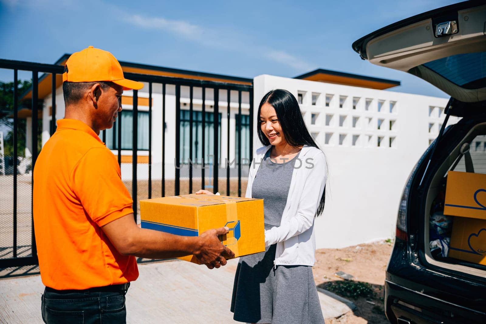 Efficient home delivery logistics depicted as a courier delivers a cardboard parcel to a smiling woman by Sorapop