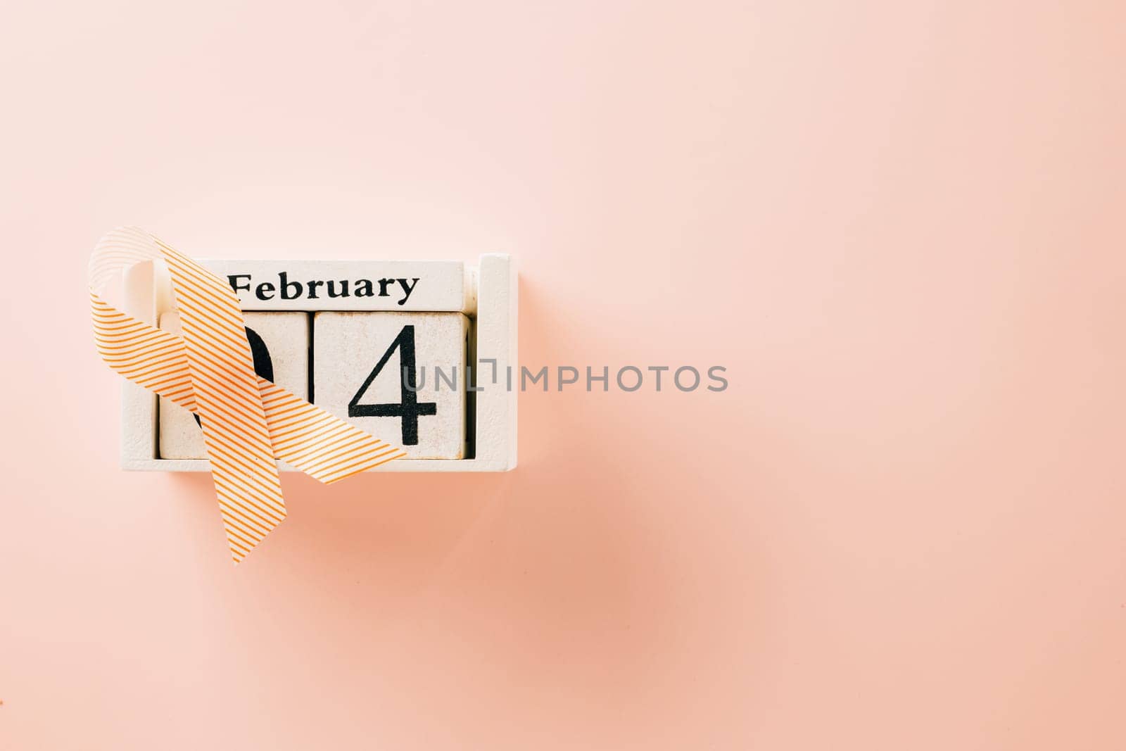 Pink awareness ribbon sign and Calender 4 February of World Cancer Day campaign on pastel pink background with copy space, concept of medical and health care support