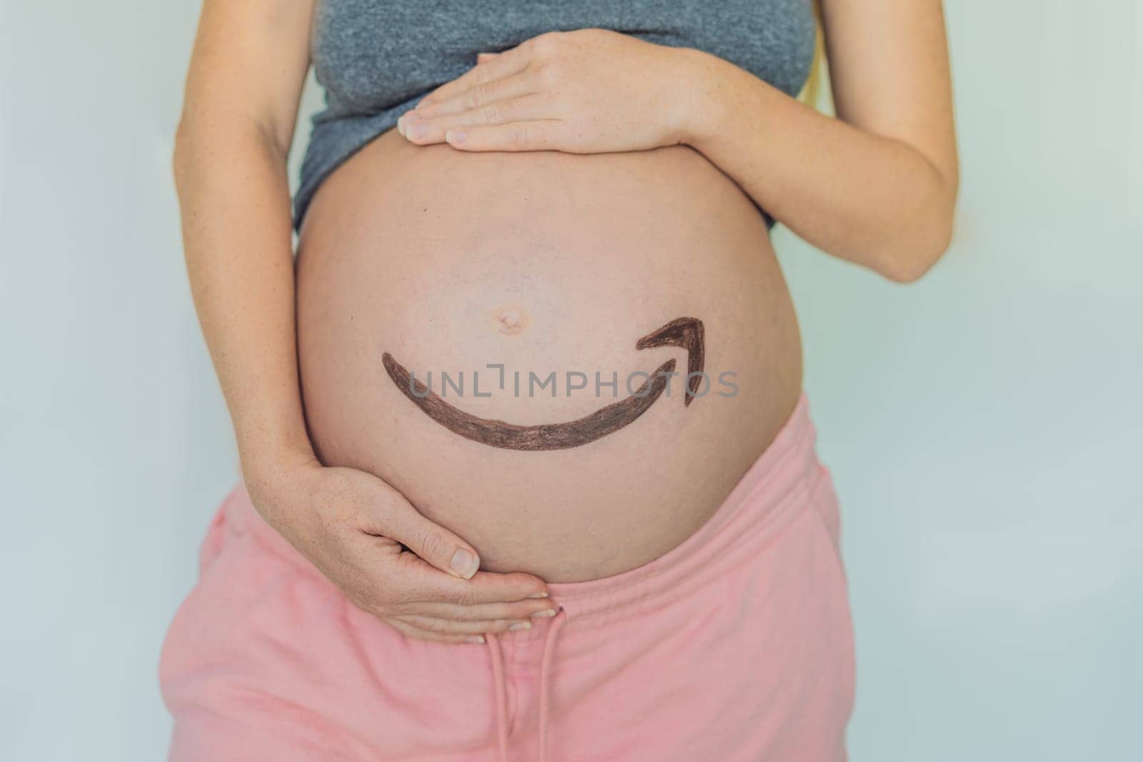 28.01.23, Mexico, Playa del Carmen: Creative concept of an Amazon icon on a pregnant belly, symbolizing the anticipation and delivery of joy, much like the reliable and timely services provided by Amazon. As well as products for pregnant women and babies on Amazon by galitskaya