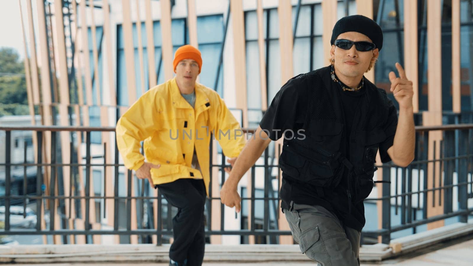 Hipster perform break dancing while partner dancing together at corridor, modern mall. Hip-hop music dancer practice footstep and move to music. Outdoor sport 2024. Active, energetic dance. Endeavor.