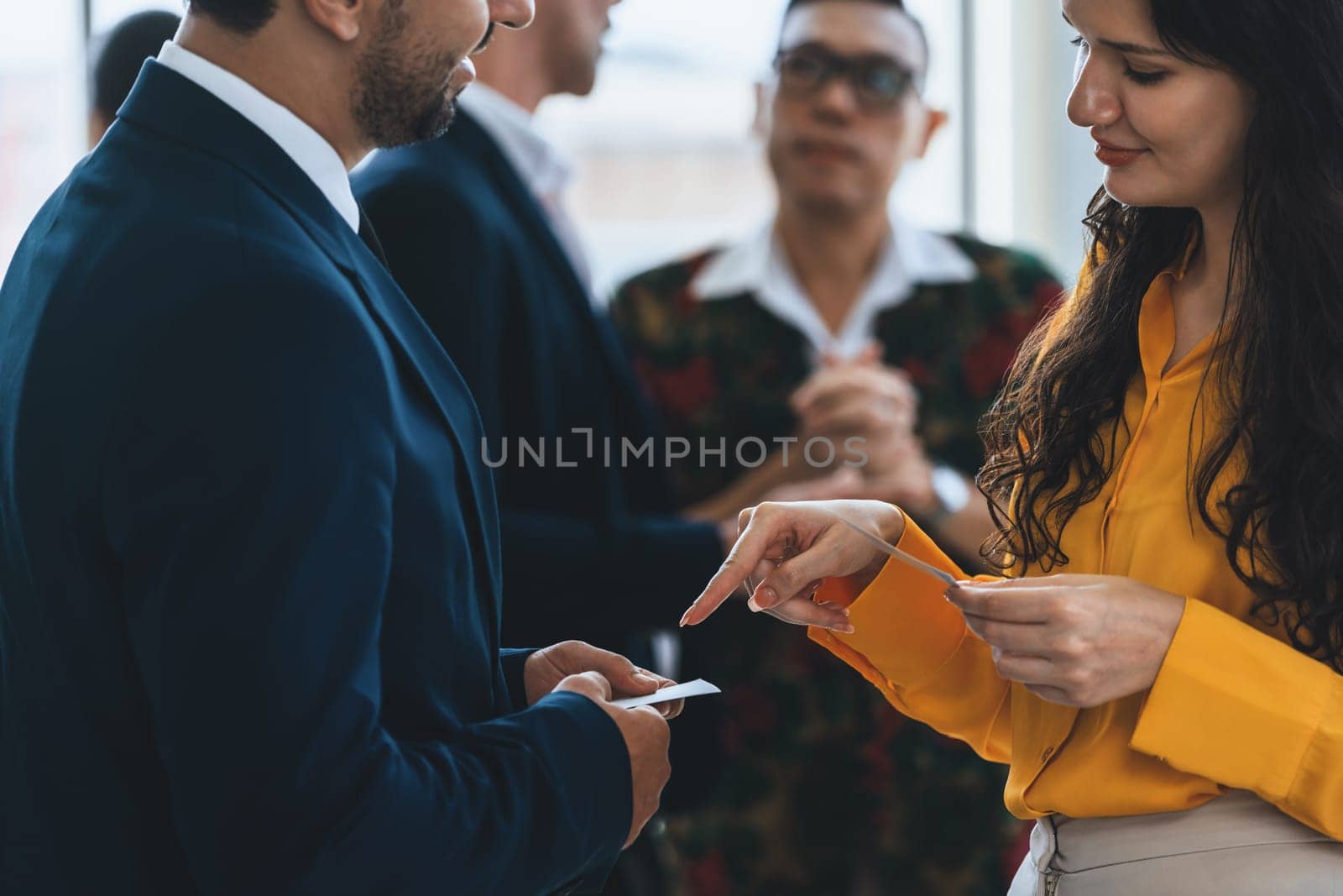 Successful businesswoman holding the name card during talking to manager about their cooperation. Cropped image of exchanging name card between businessman and businesswoman. Side view. Intellectual.
