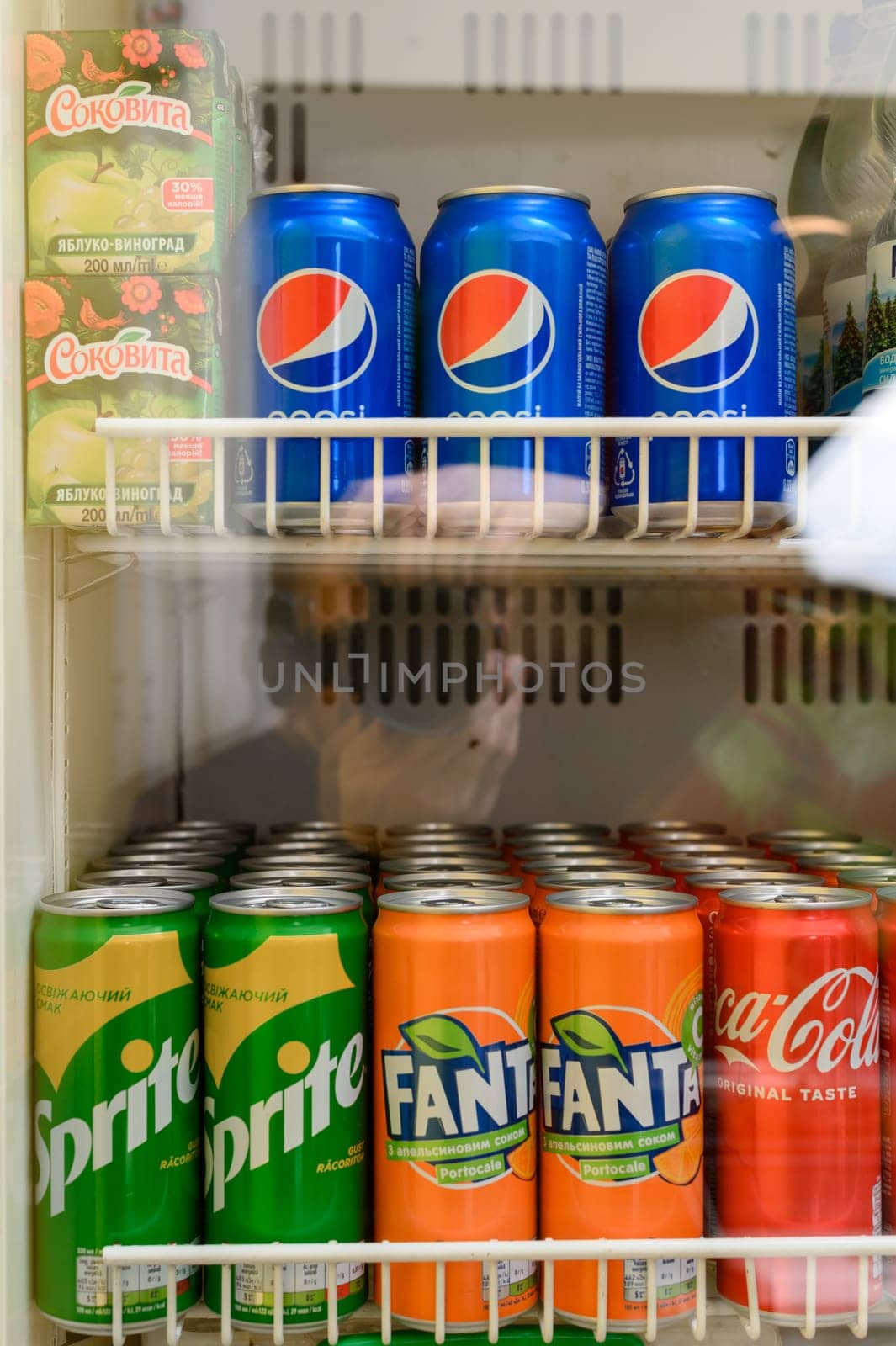 Ivano-Frankivsk, Ukraine March 26, 2023: Sprite, Fanta, Coca Cola and Pepsi drinks on the display of a refrigerator, cooling and carbonated drinks.