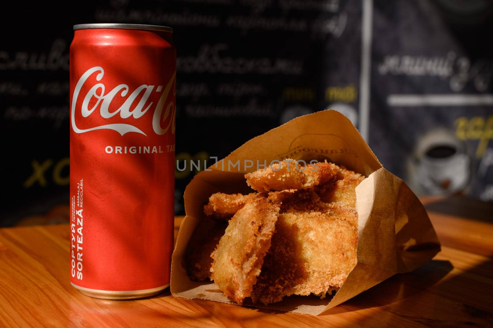 Ivano-Frankivsk, Ukraine March 26, 2023: Coca Cola and fried chicken nuggets on the table, a quick snack in a cafe.
