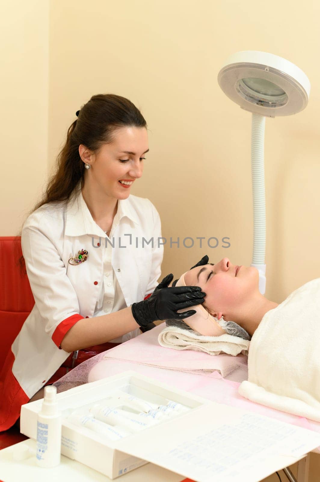 Portrait of a happy girl having a facial massage in a spa salon, relieving tension and giving her face freshness. Ivano-Frankivsk, Ukraine May 17, 2023