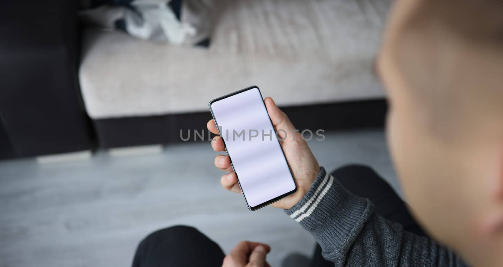 Man holds smartphone with white screen in his hand. Smartphone application development concept