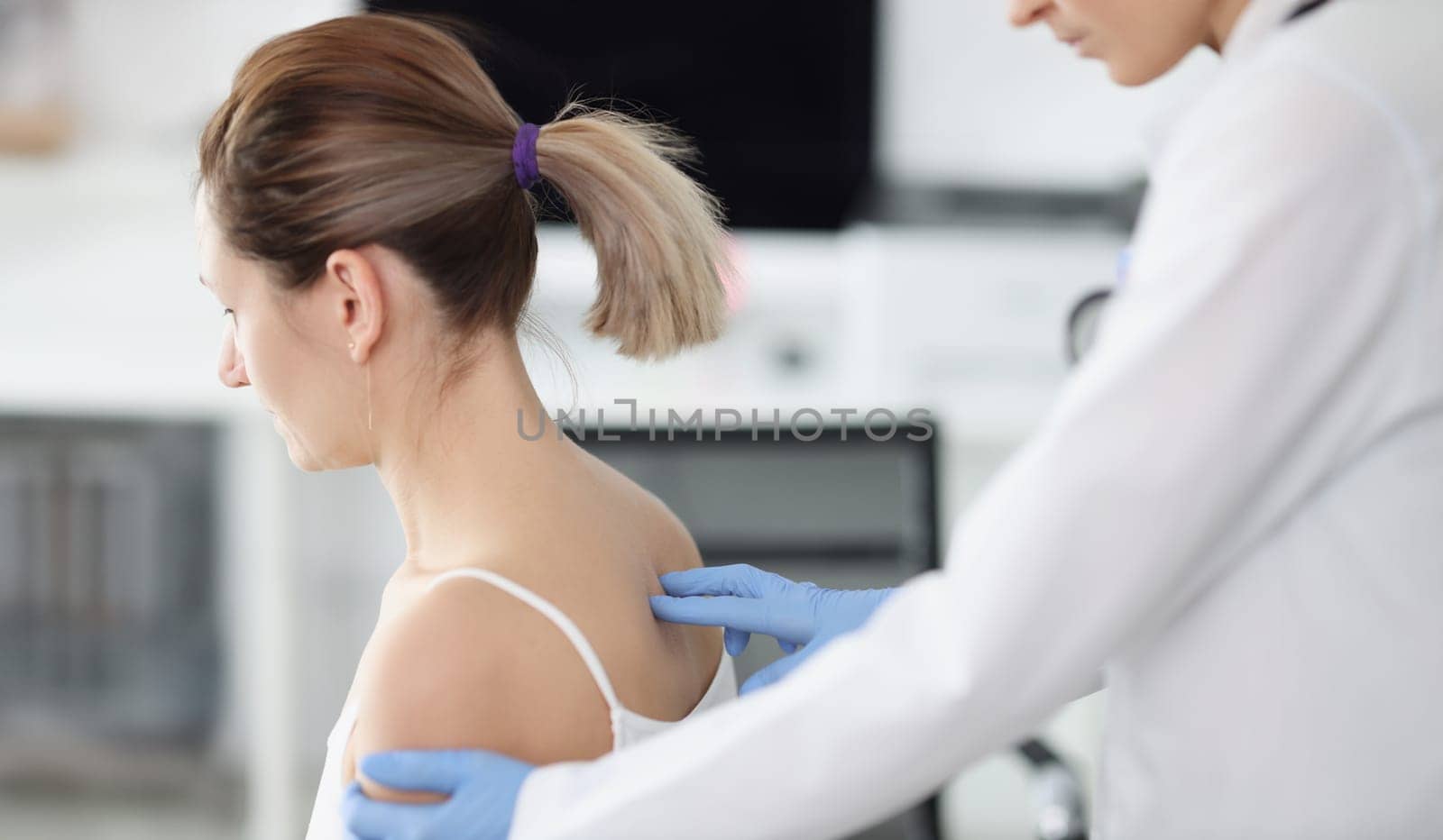 Doctor examines patient's spine in medical office. Spine disease symptoms and treatment concept