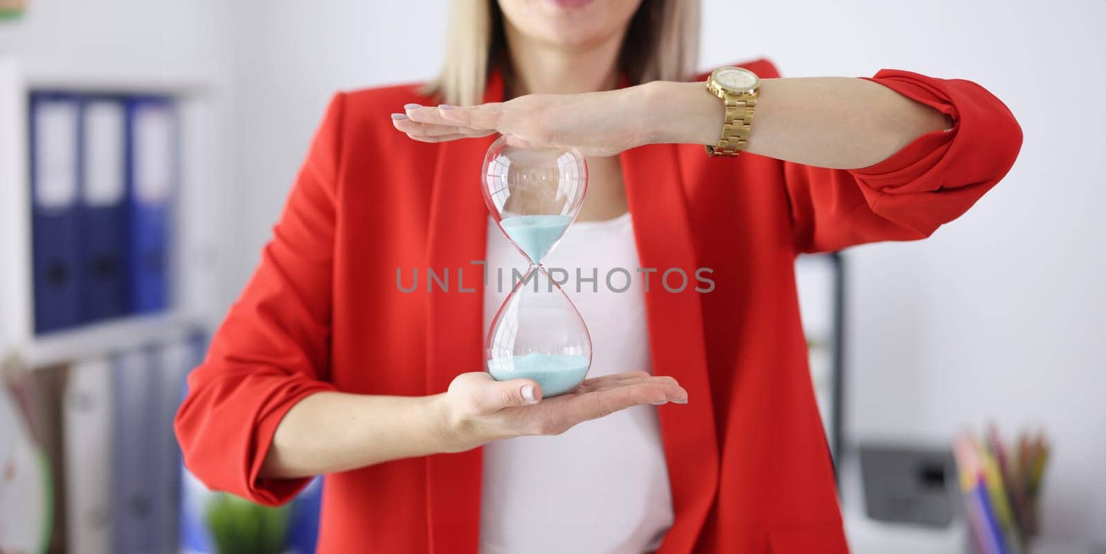 Businesswoman holds an hourglass in her hands. Employee working time control concept