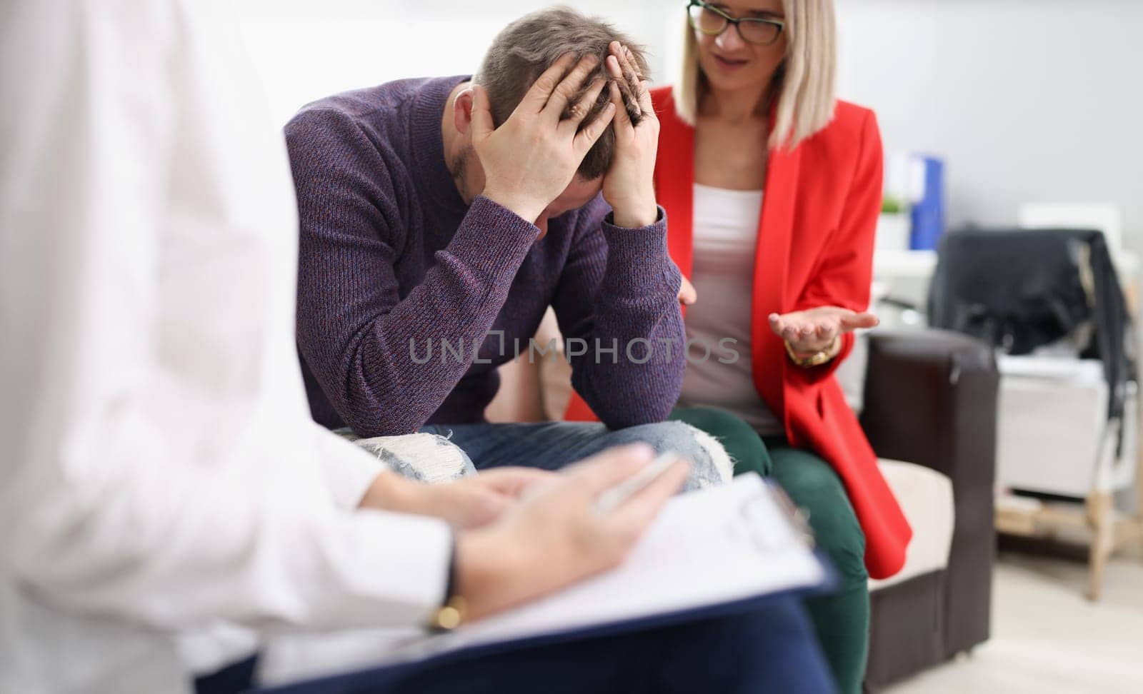 Upset man with woman at psychotherapist appointment. Psychological help in family relationships concept