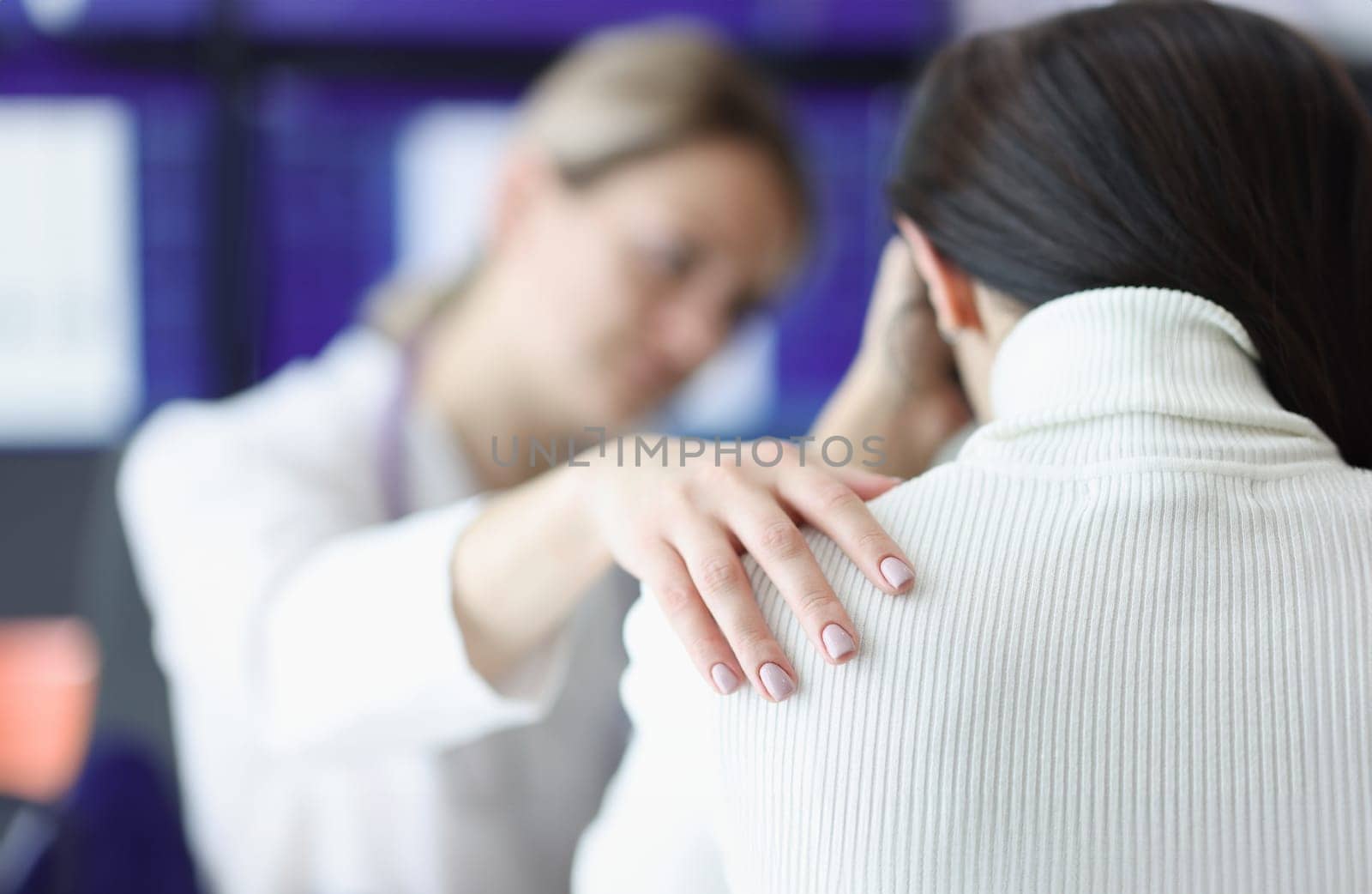 Physician holds upset patient shoulder sympathetically closeup by kuprevich